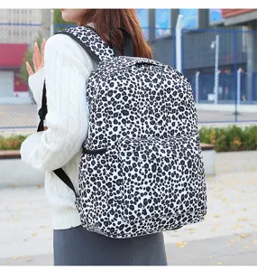 Vue détaillée du sac à dos à imprimé léopard noir et blanc en extérieur avec texture.