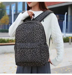 Vue détaillée du sac à dos décontracté léopard, avec poche avant zippée et bretelles.