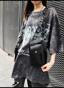 Detailed view of black PU leather tactical chest bag with metallic hardware and multiple pockets.