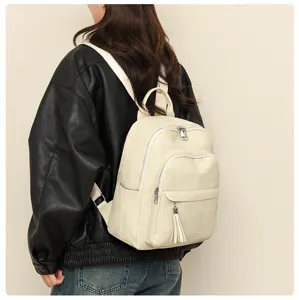 Detailansicht des stilvollen cremefarbenen weichen Lederrucksacks mit eleganter Quaste.