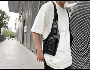 Detail view of a stylish black PU leather tactical vest bag, urban street style design.
