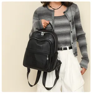 Detailansicht des schwarzen Damen Rucksacks aus weichem Leder mit modischem Quastenanhänger.