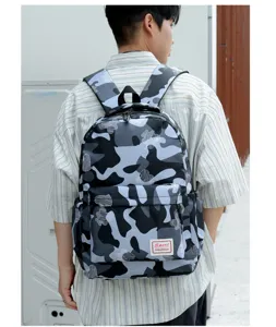 Detailansicht des grauen Camouflage-Rucksacks am Modell mit praktischer Fronttasche.