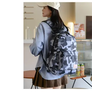 Detailansicht des Camouflage-Rucksacks am Modell, zeigt Musterstruktur und Seitenansicht.