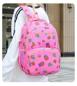 Gros plan detaille du sac a dos rose avec motif d'ours porte par un modele en exterieur.