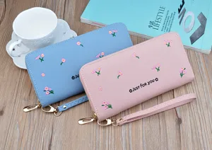 Long women wallet detail view featuring cute floral embroidery and a matching wrist strap.