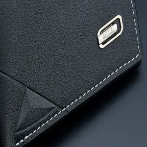 Gros plan detail de portefeuille homme en cuir noir avec surpiqûre geometrique et logo.