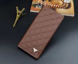 Brown men's long leather wallet detail showing diamond quilted texture and stylish metal badge.