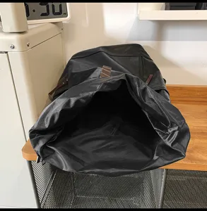 Gedetailleerd overzicht van zwarte PU-leren roll-top rugzak, met binnenvak en materiaalstructuur.