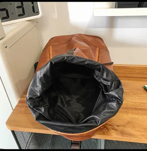 Gedetailleerd overzicht van de bruine PU lederen roll-top rugzak met grote opbergruimte.
