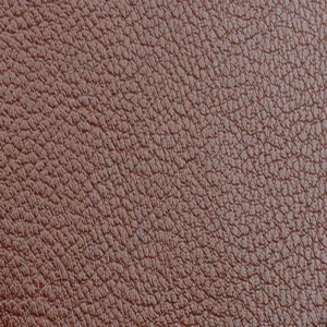 Gros plan détaillé de la texture en cuir grain litchi marron de qualité, souple et durable.