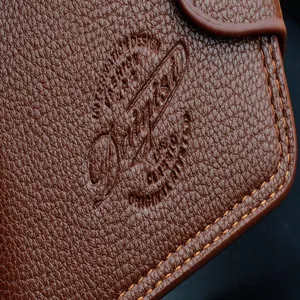 Vue détaillée d'un portefeuille court pour homme en cuir marron avec un grain fin et coutures fines.