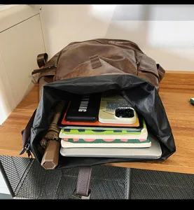 Detailopname van de bruine PU-leren rugzak met grote capaciteit en ruim opbergvak aan de binnenkant.