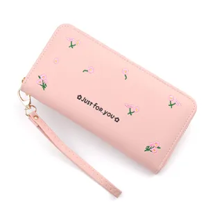 Elegant pink women long wallet featuring floral embroidery, secure zipper and wrist strap.