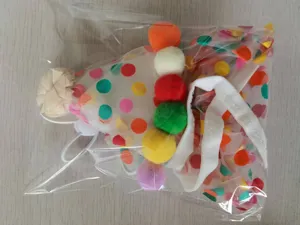 Detailed close-up view of cute pet party birthday hat with colorful pom poms and mesh.