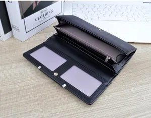 Gros plan détaillé d'un portefeuille long pour femme noir avec plusieurs emplacements et poche.