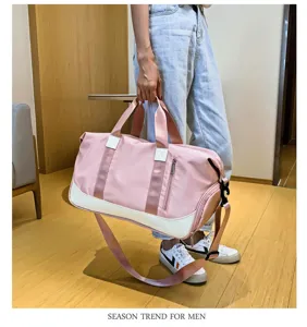 Vista detallada de una elegante bolsa deportiva rosa con correa para el hombro y bolsillo.