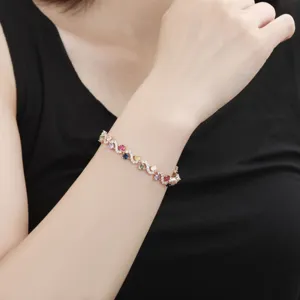 Close-up detail of a fashionable women's multi-color cubic zirconia cross bracelet jewelry.