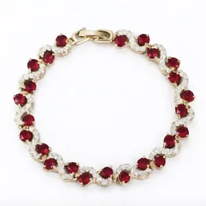 Stunning wave-shaped gold-tone bracelet detailed with brilliant red and clear zirconia stones.