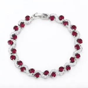 Elegant silver tennis bracelet featuring cross-set red stones and sparkling cubic zirconia.