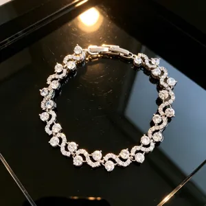 Exquisite silver-tone tennis bracelet featuring sparkling cubic zirconia in S-curve design.