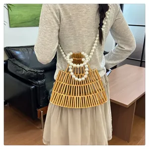 Vista dettagliata di una borsa in bambù intrecciata a mano con elegante cinturino di perle.