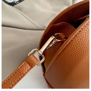 Detail van bruin gestructureerd leren crossbody tas, premium metalen hardware sluiting, elegant.