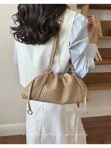 Vue détaillée d'un sac porté épaule beige tressé élégant, mettant en valeur son design en cuir.