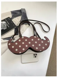 Detailed shot of quirky mustache shaped shoulder handbag with cute white polka dots, unique design.