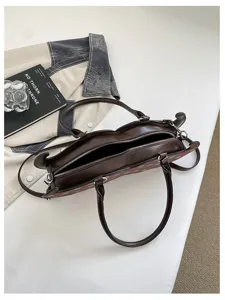 Detailed view of trendy brown leather underarm shoulder bag with unique design and zipper closure.