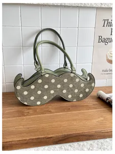 Green polka dot unique shaped handbag, trendy underarm bag for daily commute and fashion wear.