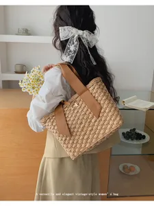 Gedetailleerd overzicht van een geweven stro tas met lederen bandjes en elegante stijl.
