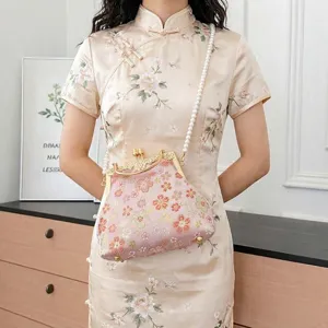Vintage geborduurde bloemen kiss lock schelp handtas met elegante parelriem voor vrouwen.