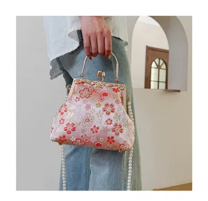 Stijlvolle geborduurde stoffen handtas met knipsluiting, vintage avondtas met parelketting.