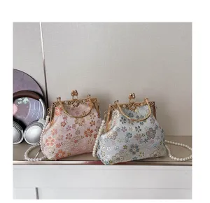 Gedetailleerd overzicht van vintage bloemen brokaat kets slot schelp handtassen met parelriemen.