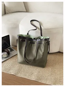 Detailaufnahme der grünen Nylontasche mit braunen Ledergriffen und elegantem Kordelzug.