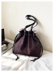Nahaufnahme der stilvollen Nylon-Beuteltasche mit Kordelzug und schwarzen Lederriemen.