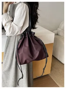 Detailansicht der Freizeittasche aus Nylon in Dunkelviolett mit schwarzen Lederriemen und Kordeln.