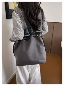 Detailansicht der grauen Nylontasche mit schwarzem Riemen und Metallösen im Innenbereich