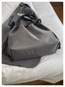 Detailansicht graue Nylon Freizeittasche, eleganter Shopper mit schwarzen Trägern.