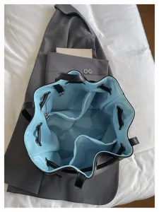 Innendetail der schwarzen Beuteltasche mit hellblauem Futter und vielen Fächern.