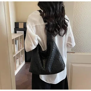 Detailaufnahme einer schwarzen geflochtenen Ledertasche mit hochwertiger Verarbeitung.