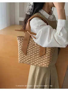 Stijlvolle geweven strooien handtas met elegant lederen handvat en strik voor de zomer.