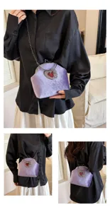 Detailansicht der violetten Samt Abendtasche mit antikem Herz Metallverschluss.