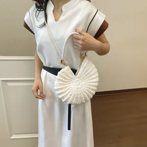 Chic woven seashell handbag for women, stylish conch beach bag with pearl strap.