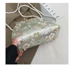 Elegante geborduurde bloemen schelp handtas met parelriem voor feestelijke avonden uit.