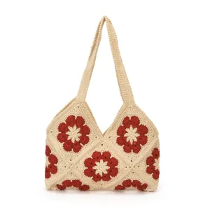Handgefertigte Häkel-Schultertasche mit rotem Blumenmuster, ideal für Strand und Alltag.