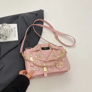 Rosa Umhängetasche im Bikerjacken-Stil mit Nieten, Kette und floralen Details für Damen.