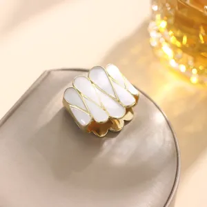 Primer plano detallado del elegante anillo de pañuelo y clip geométrico de esmalte blanco.