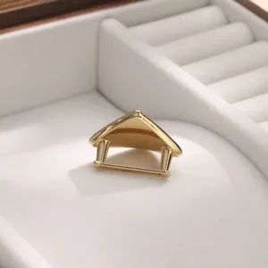 Close-up detail of a minimalist gold metal scarf buckle, showcasing its unique geometric design.